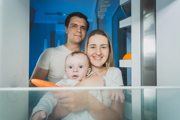 Pohled z lednice na usmívající se rodina hledá — Stock fotografie