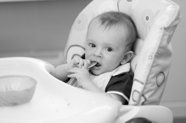 9 aylık bebek highcha içinde oturma portre siyah ve beyaz