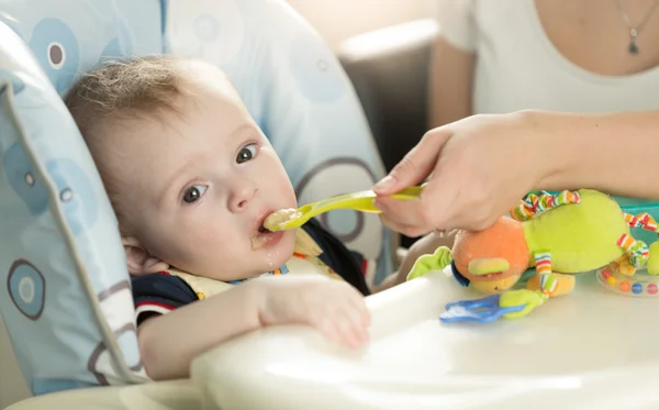 Primer plano del niño comiendo puré de cuchara —  Fotos de Stock