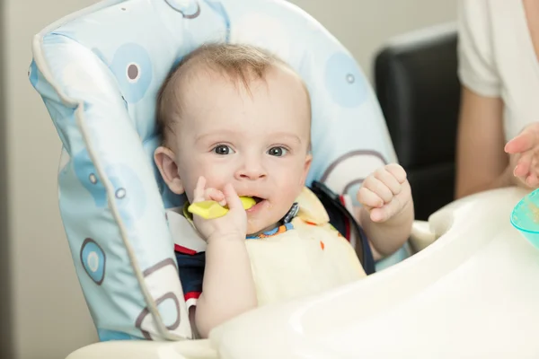 Hermoso niño de 9 meses con cuchara sentado en trona —  Fotos de Stock