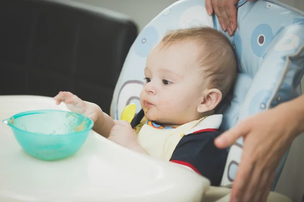 Niño de 9 meses sentado en silla alta y buscando un plato —  Fotos de Stock