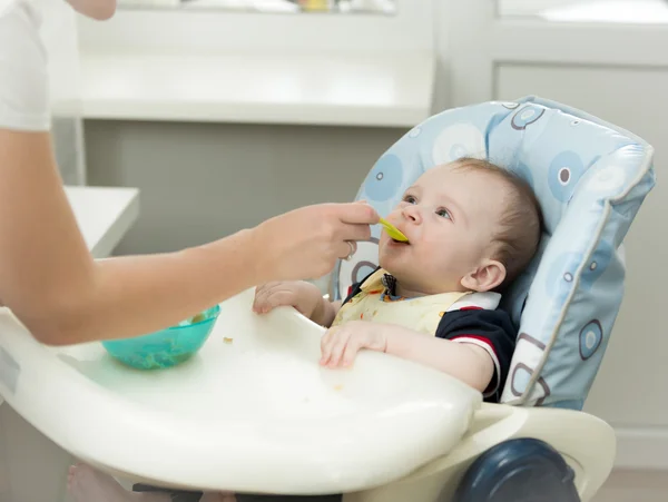 Primer plano de la madre dando gachas de cuchara a su bebé —  Fotos de Stock