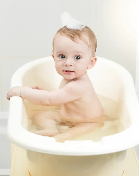 Bebé niño jugando en espuma mientras toma el baño — Foto de Stock