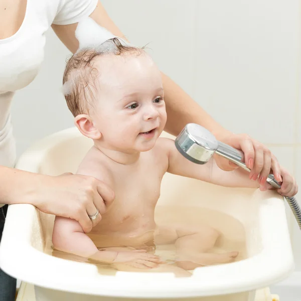 Primer plano de la madre bañando a su lindo bebé en el baño — Foto de Stock