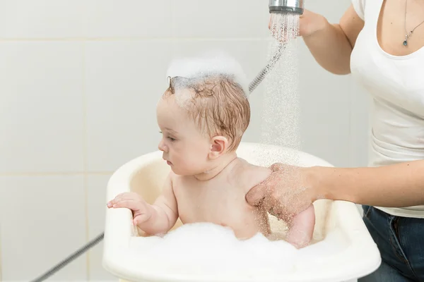 Niedlicher kleiner Junge sitzt in einer Badewanne voller Schaum — Stockfoto