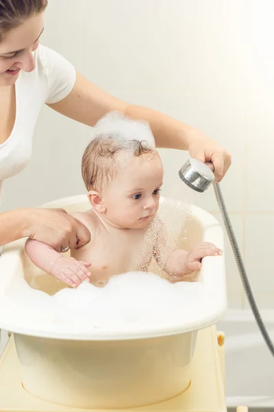 Bayi laki-laki lucu bermain di kamar mandi dengan kepala mandi — Stok Foto