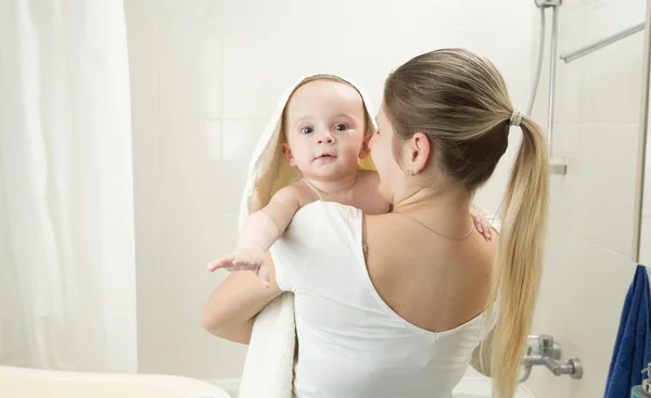 Mother holding her baby in towel at bathroom — Stock Photo, Image