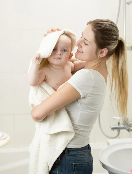 ハヴィ後タオルで彼女の赤ちゃんを拭く笑顔の母の肖像 — ストック写真