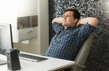 Genç adam rahatlatıcı mola sırasında ofiste iskemle