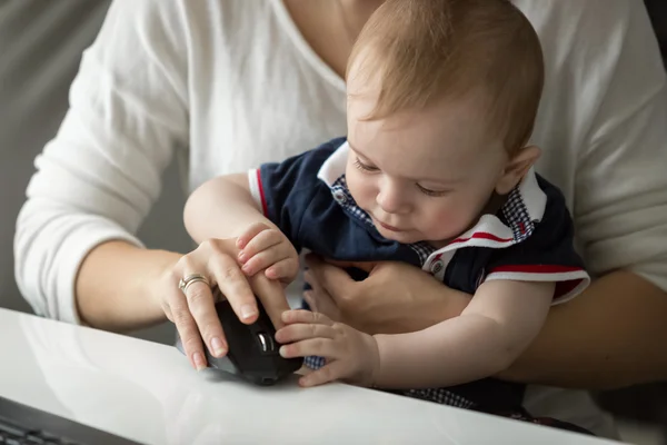 Primer plano de lindo bebé niño sentado en las madres regazo y jugando con — Foto de Stock