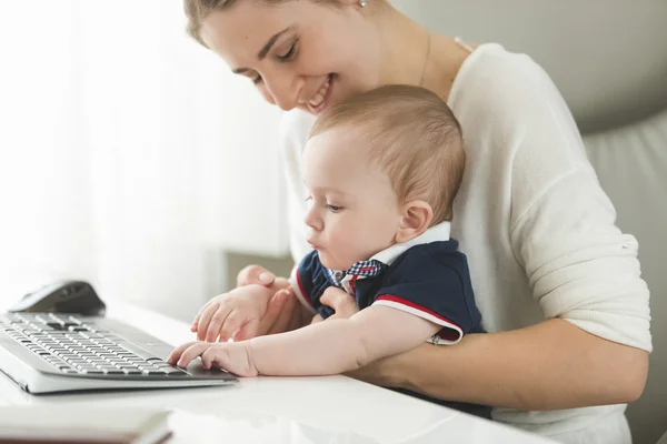 Ung kvinna ta hand om baby på kontor — Stockfoto