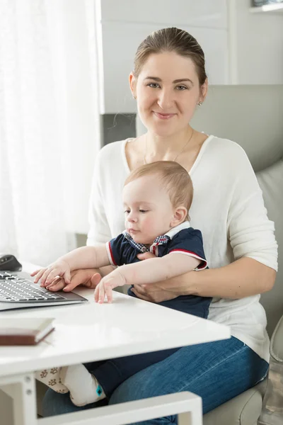 笑顔の実業家のオフィスで彼女の赤ちゃんとポーズ — ストック写真