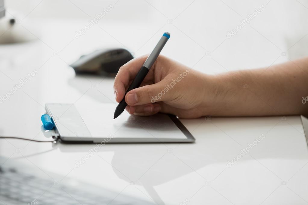 Toned photo of  graphic designer drawing on digital graphic tabl