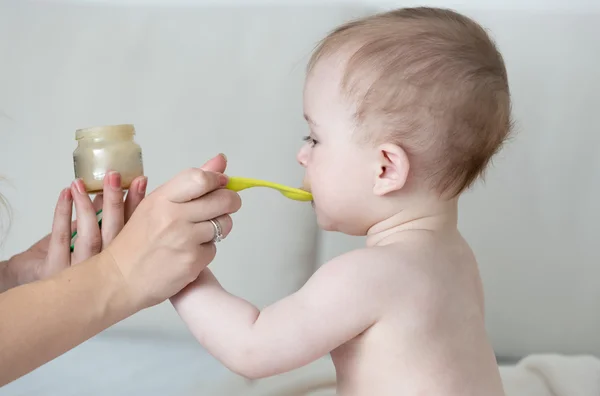 Anne sebze püresi ile onun erkek bebek besleme portresi — Stok fotoğraf