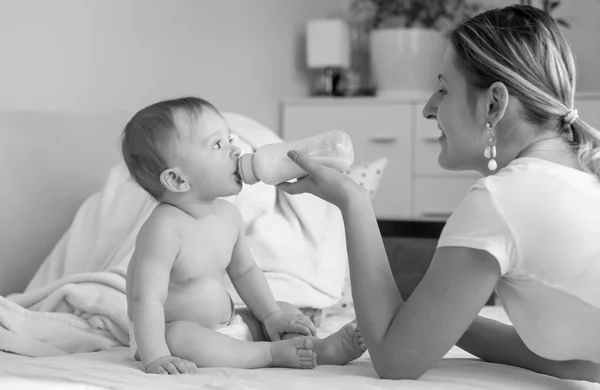 Foto em preto e branco de mãe sorridente alimentando-a com 9 meses de idade — Fotografia de Stock