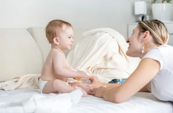 Feliz joven madre hablando con su bebé de 9 meses sentado en — Foto de Stock