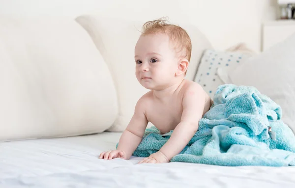Baby pojke efter dusch omfattas i blå filt på soffan på living — Stockfoto