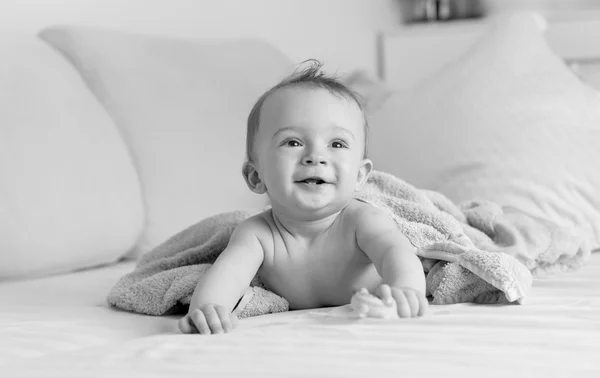 Portrait noir et blanc d'un petit garçon riant allongé sous un voile — Photo