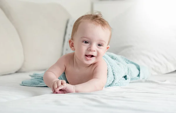 9 hónapos kisfiú feküdt a kanapén élő r kék törölköző alatt — Stock Fotó