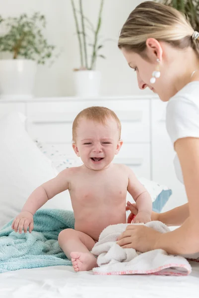 Anya megnyugtató neki sírás baba fiú ül ágyas — Stock Fotó