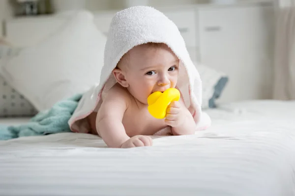 Entzückender kleiner Junge in Handtuch gehüllt hält gelbe Gummiente in — Stockfoto