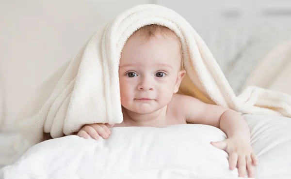 Retrato del niño acostado en la cama bajo la toalla después de bañarse — Foto de Stock