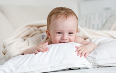 Neşeli bebek boy gülümseyerek beyaz yastık o rahatlatıcı portresi