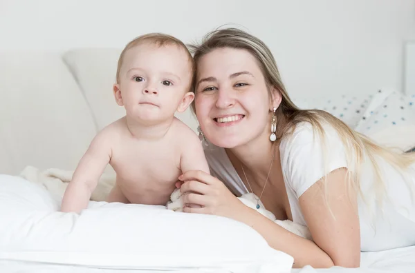 Retrato de niño sonriente feliz y la madre acostada en la almohada un —  Fotos de Stock