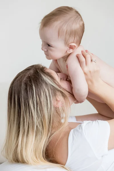 Öpüşme ve onun 9 ay o ile oynayan genç anne portresi — Stok fotoğraf