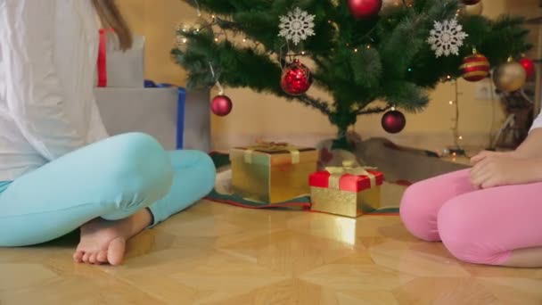 Närbild av två flickor söker insidan Christmas presentaskar — Stockvideo