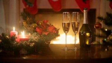 Şampanya ve yanan Noel mumlar oturma odasında şömine masada üzerinde gözlük dolu
