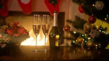 Noel masa ile iki bardak şampanya oturma odasında şömine yakarak yaktı