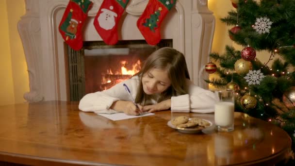 Hermosa niña de 10 años escribiendo carta a Santa Claus con deseos — Vídeo de stock
