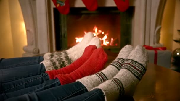 Closeup of family feet in woolen socks warming by the fireplace decorated for Christmas — Stock Video