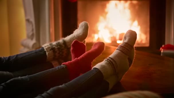 Closeup rodiny ve vlněných ponožek oteplování hořícího krbu v domě