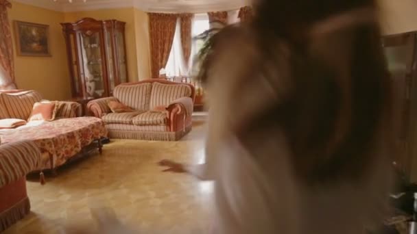 Две взволнованные девушки бегут в гостиную после Рождества, чтобы открыть подарки — стоковое видео
