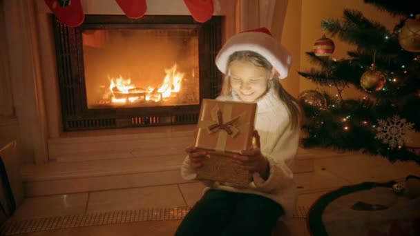 Boldog, izgatott lány ül a kandalló portréja nyitja meg a karácsonyi ajándék doboz — Stock videók