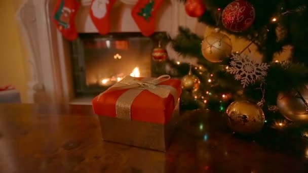 Dolly beschoten rond de gift van Kerstmis in vak woonkamer met open haard branden — Stockvideo