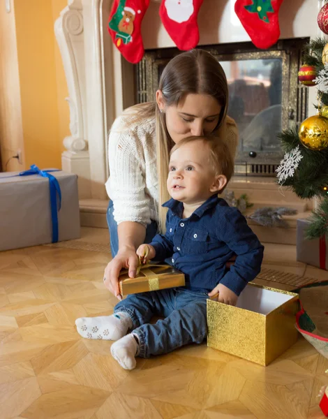 Lycklig mamma kysser hennes baby son på julgran — Stockfoto