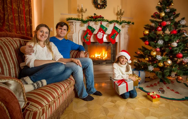 Χαμογελώντας η οικογένεια ποζάρει στο σαλόνι διακοσμημένο για το πνεύμα των Χριστουγέννων — Φωτογραφία Αρχείου