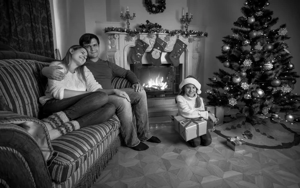 Svartvit bild av glad familj avkopplande nära spisen på — Stockfoto