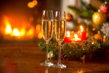 Fireplac yanan iki şampanya flüt ile Noel arka plan