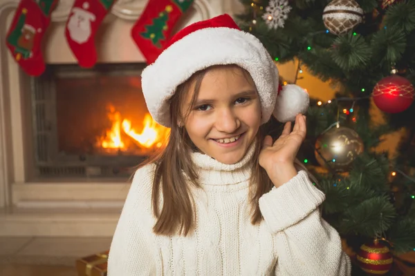 Porträt eines Mädchens in weißem Pullover und Weihnachtsmütze, das bei Burnin posiert — Stockfoto