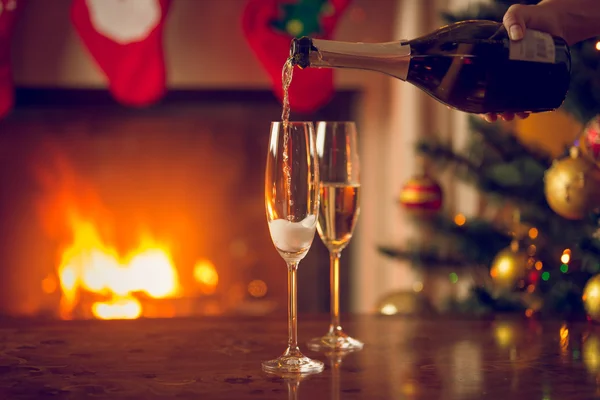 Glasögon som fylls med champagne på bordet bredvid jul t — Stockfoto