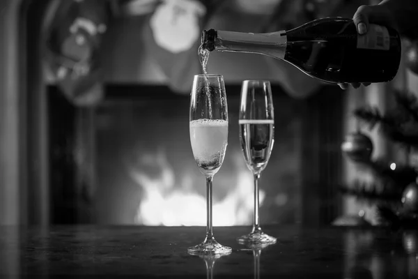 Foto en blanco y negro de la botella de mano y vasos de llenado —  Fotos de Stock