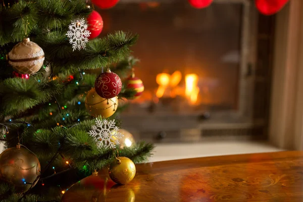 Imagem de close-up de bugigangas douradas na árvore de Natal na frente do bu — Fotografia de Stock