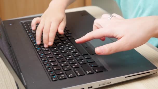 Primer plano de manos y dedos femeninos e infantiles escribiendo en el teclado del portátil. Educación y estudio utilizando computadoras y tecnología moderna — Vídeos de Stock