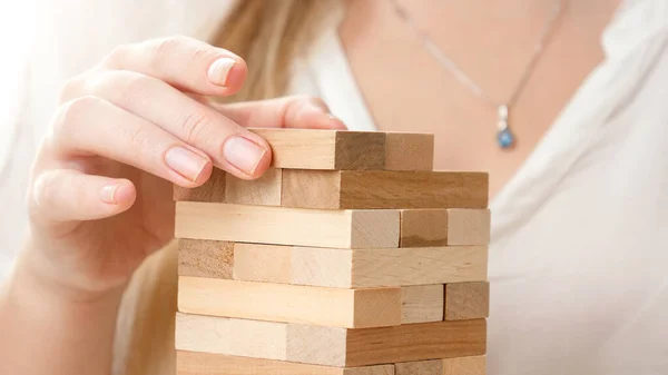 Gros plan de femme d'affaires mettant des blocs et des briques de haute tour. Concept de stabilité, de développement, de réussite et de croissance des entreprises. Bâtir et développer des entreprises — Photo