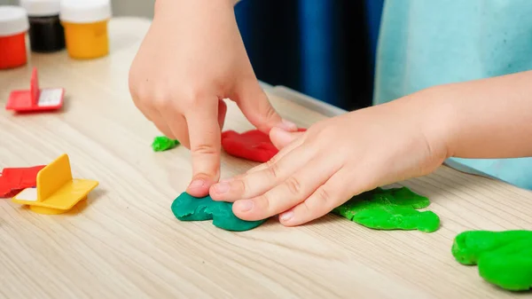 Primo piano di modellatura bambino e stampaggio argilla colorata o pasta in mano. Educazione dei bambini e sviluppo della cretività — Foto Stock