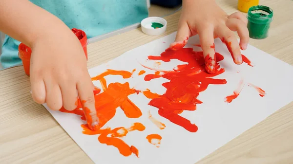 Primo piano di bambino che dipinge e disegna con le dita su carta bianca. Concetto di educazione dei bambini, sviluppo della creatività e arte. — Foto Stock